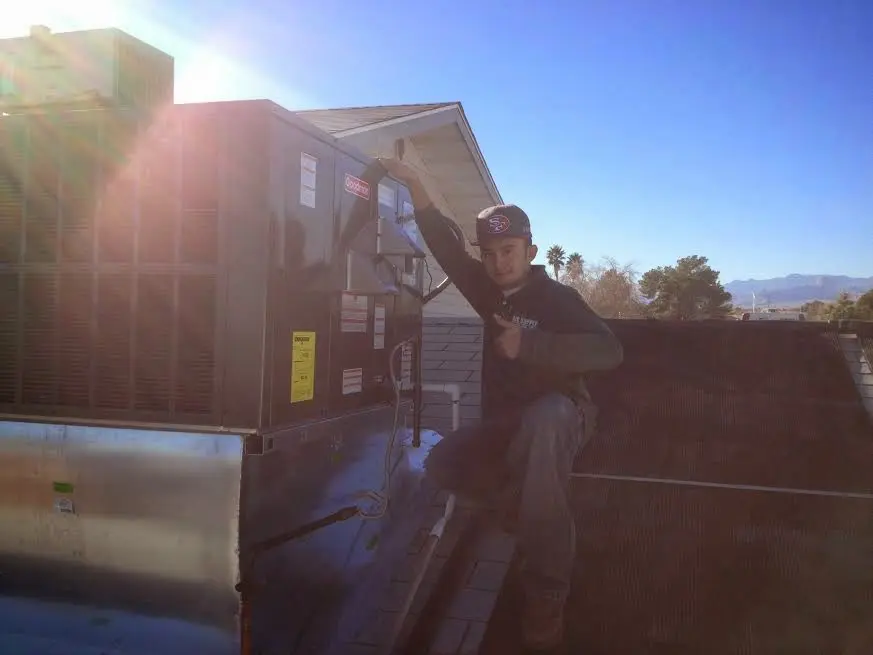 HVAC technician performing AC Tune-Up on a rooftop unit in Wendell