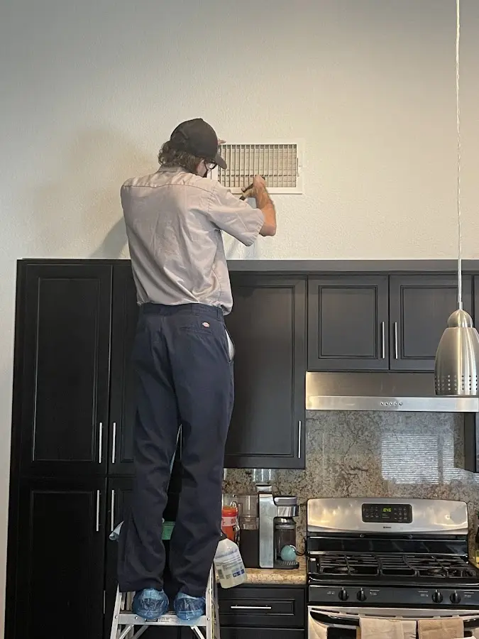 Technician inspecting an air vent during HVAC service in Wendell